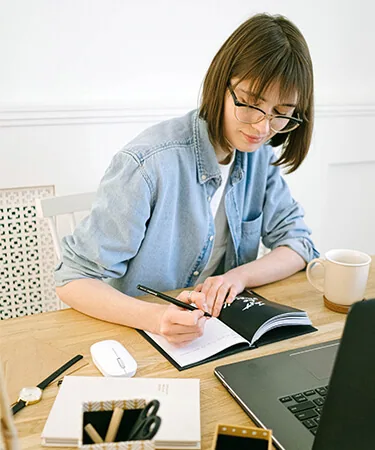 تدوين ملاحظات بجوار حاسوب محمول